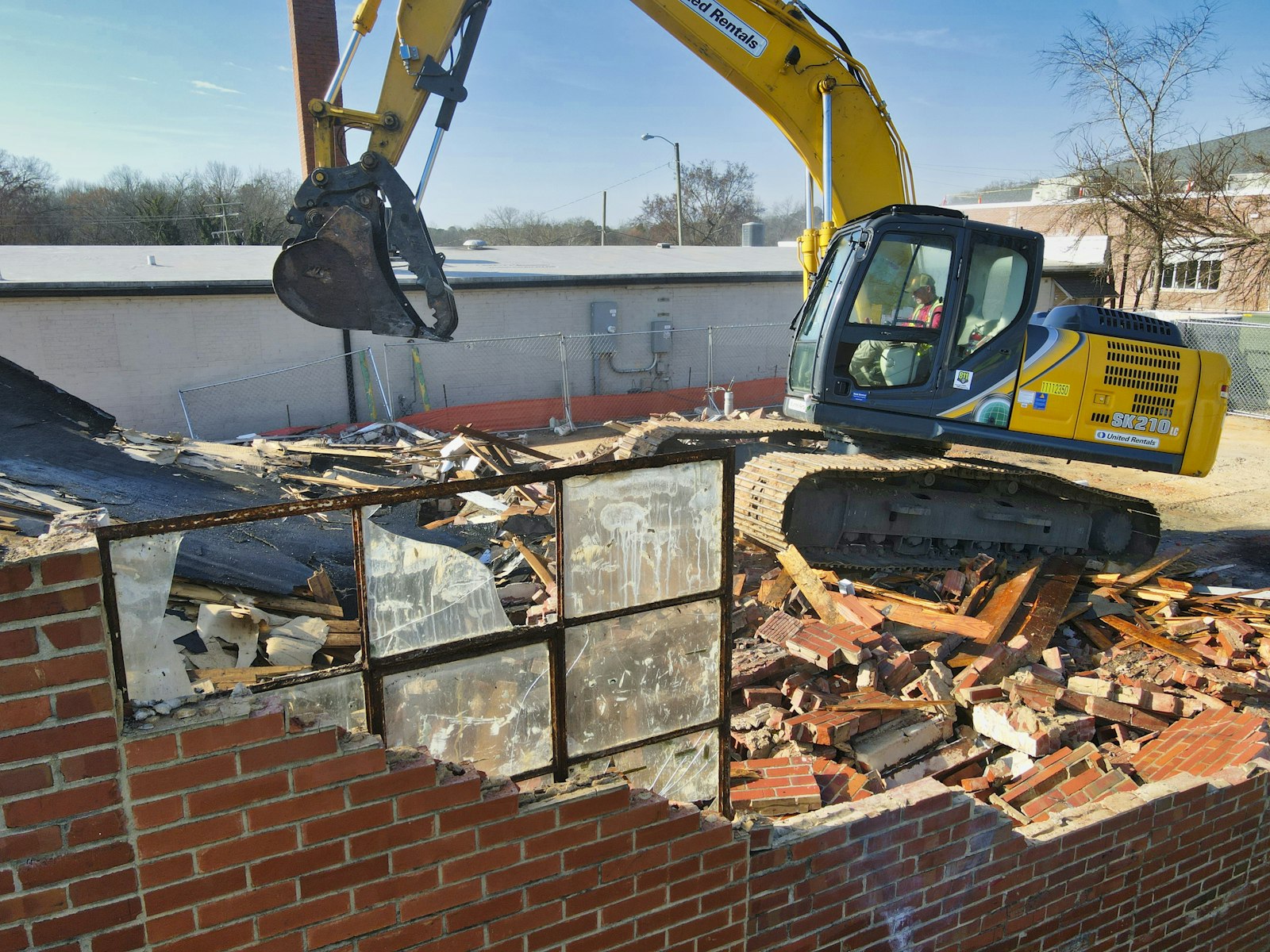 Excavadora demoliendo una vivienda para construir una casa nueva en el mismo lote