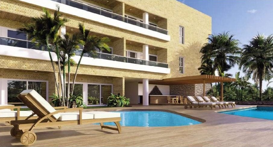Render de la piscina de Margarita Real 2, con tumbonas frente al edificio de tres plantas